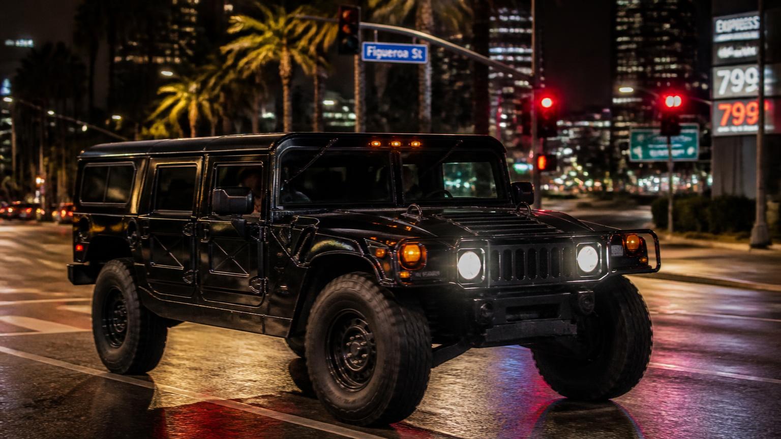 Black Hummer H1 on a wet Los Angeles street at dusk